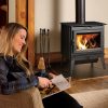 Woman reading next to a wood stove